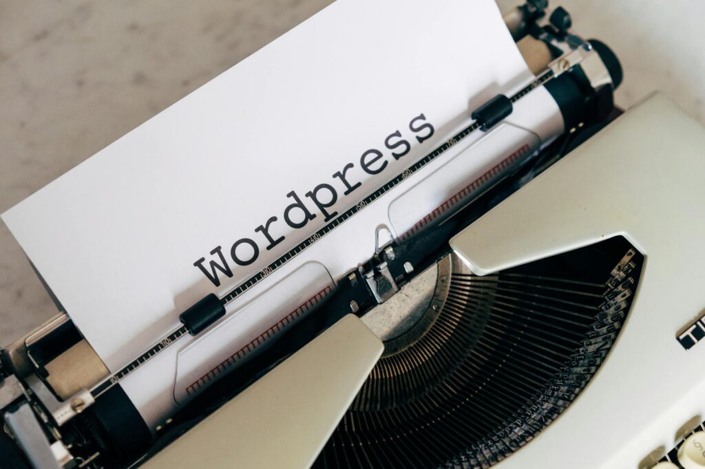 Close-up of a vintage typewriter with a paper displaying 'WordPress', ideal for blogging and writing concepts.